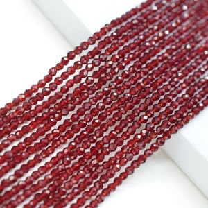 May include: A strand of red garnet beads, faceted and strung together. The beads are small and uniform in size, creating a smooth and elegant look.
