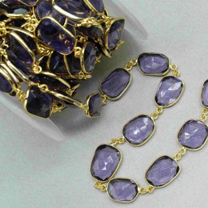 Puede incluir: Una hebra de cuentas de piedra preciosa de amatista conectadas por eslabones de cadena de oro. Las cuentas son facetadas y tienen un color morado intenso. La cadena es dorada y tiene un acabado pulido.