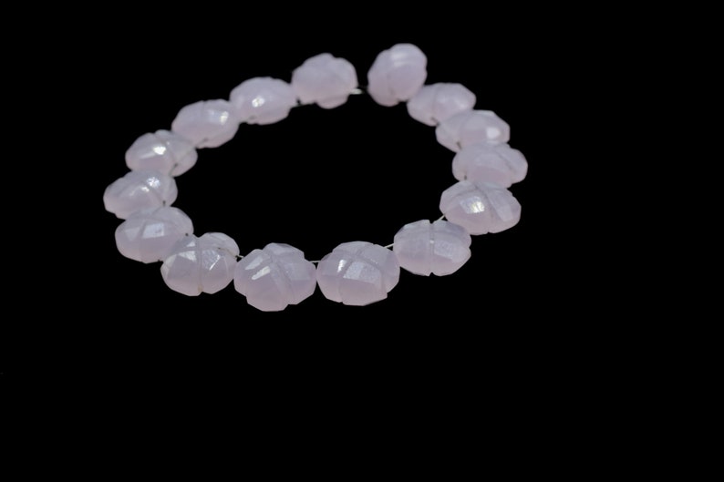 May include: A strand of pale lavender gemstone beads, each bead is faceted and shaped like a flower.