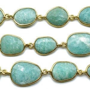 May include: A strand of light green gemstone beads with gold accents. The beads are faceted and have a smooth, polished finish.