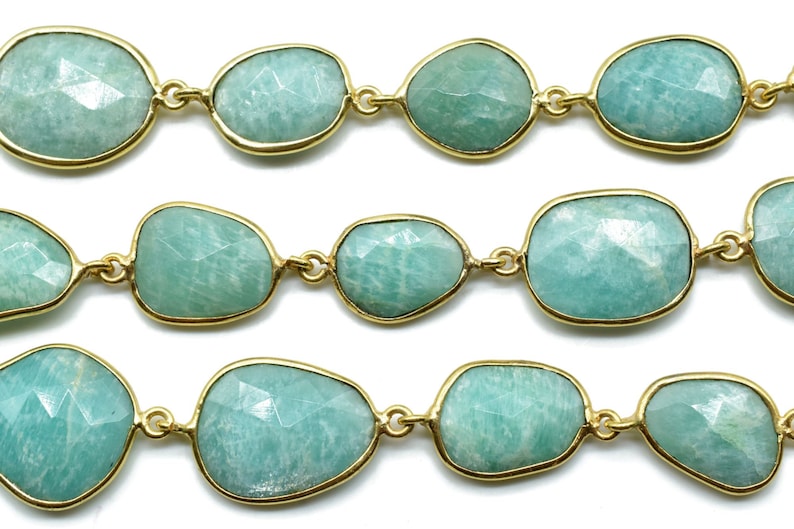 May include: A strand of light green gemstone beads with gold accents. The beads are faceted and have a smooth, polished finish.