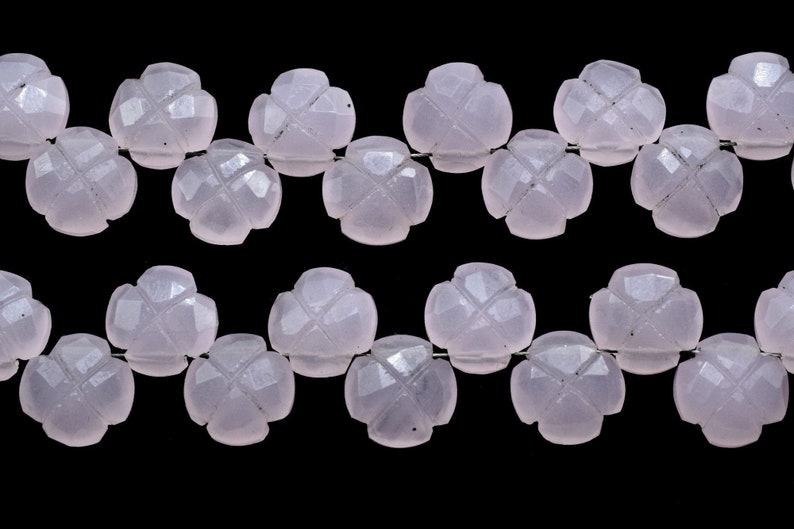May include: A strand of pale pink gemstone beads, each bead is carved in the shape of a four-leaf clover.
