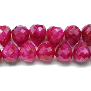 Puede incluir: Una hebra de cuentas de piedra preciosa rosa facetadas. Las cuentas tienen forma de lágrima y tienen un acabado brillante.