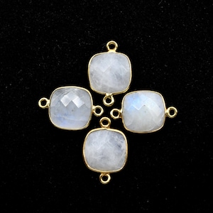 Puede incluir: Cuatro conectores de piedras preciosas de tono dorado con forma cuadrada y acabado blanco iridiscente. Los conectores tienen dos bucles a cada lado para sujetar a las joyas.