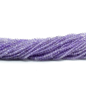 May include: A strand of light purple amethyst beads. The beads are faceted and have a slightly irregular shape. The beads are strung on a clear thread.