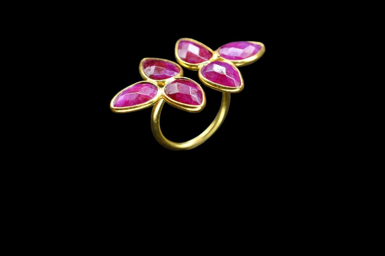 Peut inclure: Bague en or avec trois fleurs en pierres pr&eacute;cieuses roses.