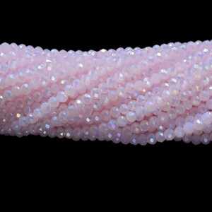 以下が含まれることがあります： ピンクの虹色のガラスビーズのストランド。ビーズはファセットカットされており、わずかに不規則な形をしています。