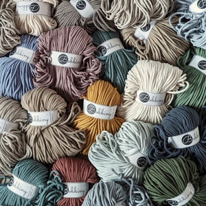 May include: A selection of cotton rope colours, each wound into a ball. The rope is labelled with the word "Bobbiny".