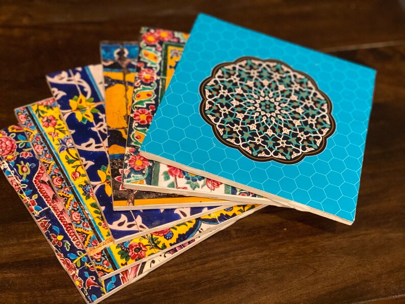 May include: A stack of colorful coasters with intricate geometric patterns. The top coaster features a blue background with a large, ornate, turquoise mandala design.
