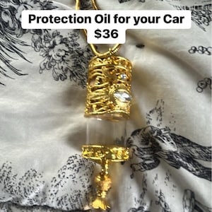 May include: A gold-colored Protection Oil bottle for cars. The bottle has a decorative filigree design and a clear glass vial. The text "Protection Oil for your Car" is visible in the image.