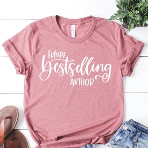 May include: A pink t-shirt with the text "Future Bestselling Author" in white lettering.