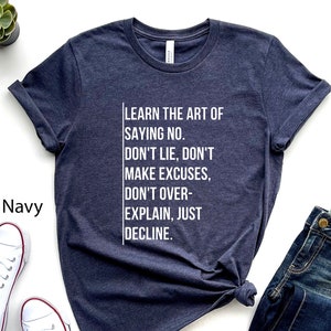 May include: Heather navy blue t-shirt with white text that reads "LEARN THE ART OF SAYING NO. DON'T LIE, DON'T MAKE EXCUSES, DON'T OVER-EXPLAIN, JUST DECLINE."