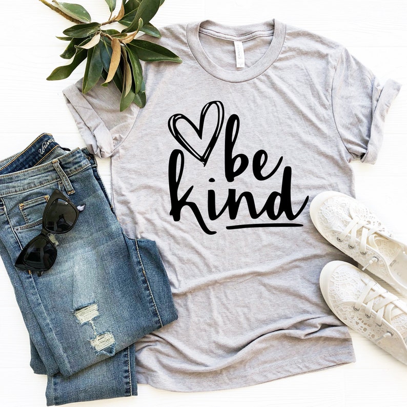 May include: A gray t-shirt with a black heart and the text "be kind" in a handwritten font.