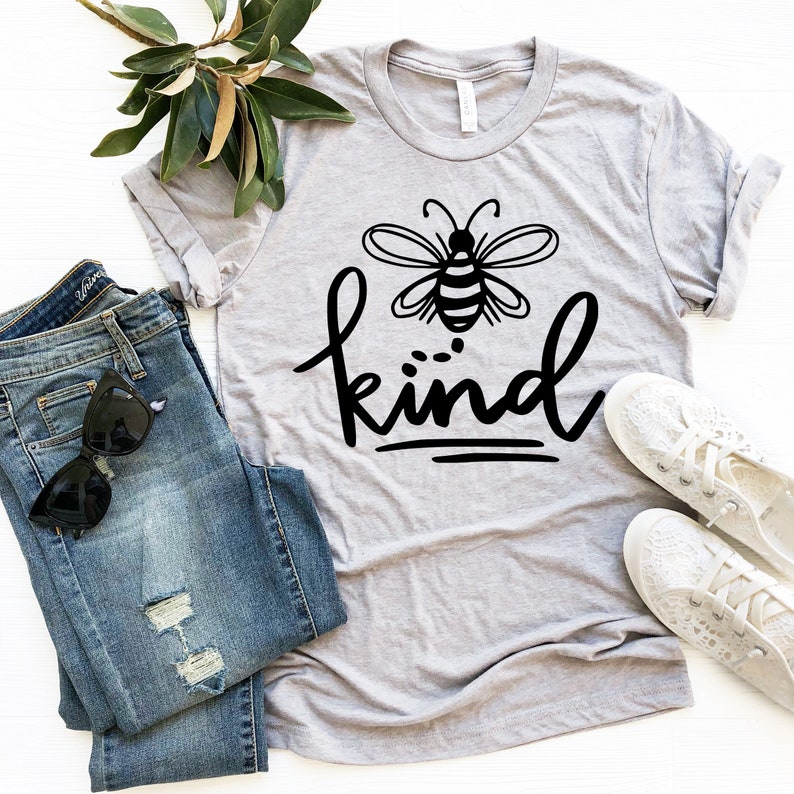 May include: A gray t-shirt with a black bee and the word "kind" written in a stylized font.