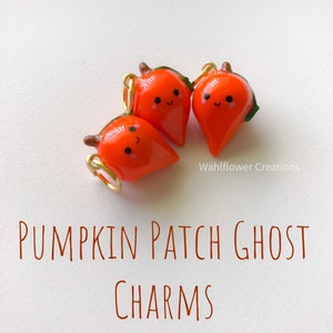 Può includere: Tre ciondoli fantasma di zucca arancioni con facce felici. I ciondoli sono fatti di pasta polimerica e hanno anelli di salto dorati.