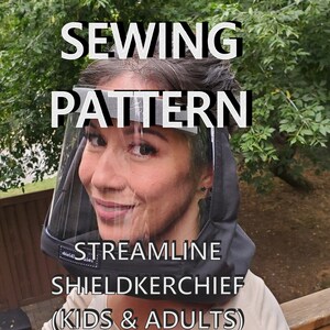 以下が含まれることがあります： 黒と透明なフェイスシールドを着用した人物。上部に「SEWING PATTERN」、下部に「STREAMLINE SHIELDKERCHIEF (KIDS & ADULTS)」の文字。背景は緑豊かな屋外環境。