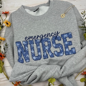 May include: A set of three ceramic mugs with a speckled, matte finish in cream, light grey, and dark grey. Each mug has a simple, minimalist design, suitable for coffee or tea.