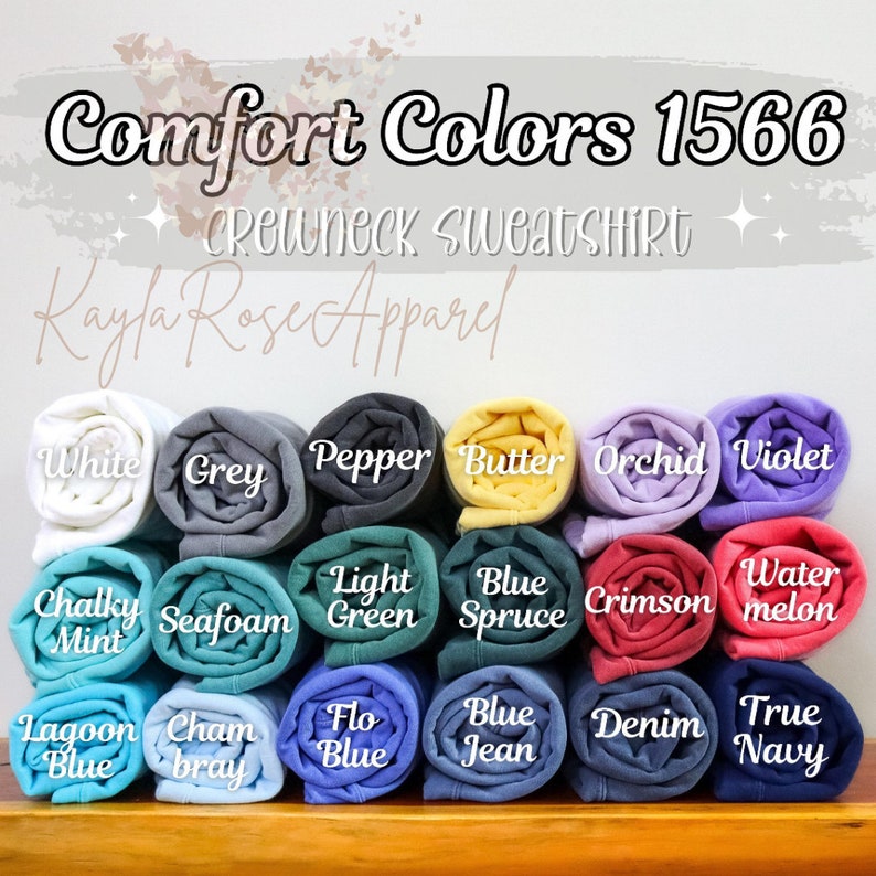 K&ouml;nnte beinhalten: Eine Sammlung von aufgerollten Comfort Colors 1566 Crewneck-Sweatshirts in verschiedenen Farben, darunter Wei&szlig;, Grau, Pfeffer, Butter, Orchidee, Violett, Kreideminze, Schaum, Hellgr&uuml;n, Blauer Fichte, Scharlachrot, Wassermelone, Lagunenblau, Chambray, Floblau, Jeansblau, Denim und Dunkelblau.