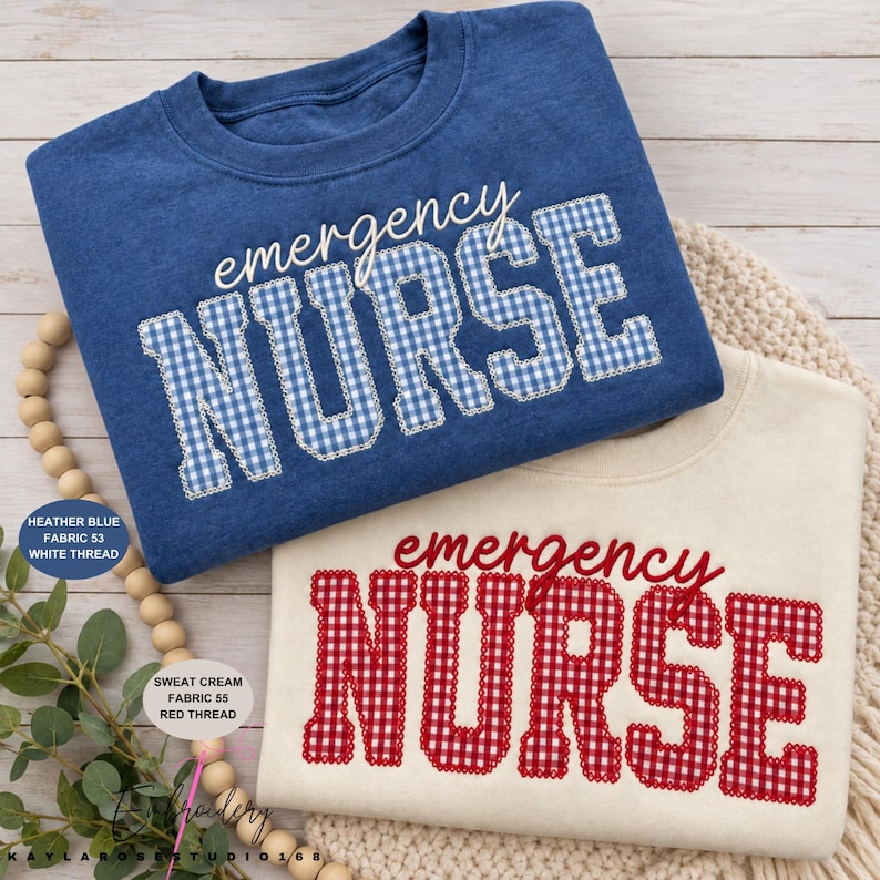 May include: A heather blue sweatshirt with the text emergency NURSE in blue and white gingham, and a cream sweatshirt with the text emergency NURSE in red and white gingham. Both feature a crew neckline and long sleeves with a textured fabric finish.