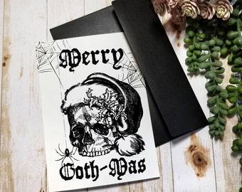 May include: Black and white illustration of a skull wearing a Santa hat with the text "Merry Goth-Mas".