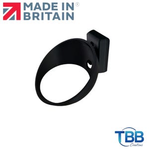 May include: A matte black circular wall-mounted holder with a rectangular base attachment. The object features a hollow ring design with a small circular opening on the side. The text MADE IN BRITAIN and TBB Creations are visible in the image.