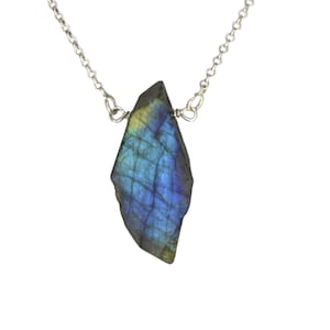Op de afbeelding: Een zilveren ketting met een grote, iriserende blauwe en groene labradorit edelsteen hanger.