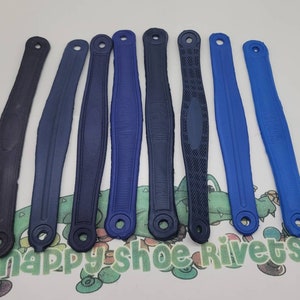 May include: Eight blue rubber shoe straps with different textures and designs. The straps are all about 10 inches long and have a hole at each end for attaching to shoes.