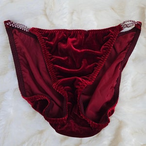 May include: Red velvet lingerie with a beaded trim. The lingerie has a low rise and a cheeky cut.