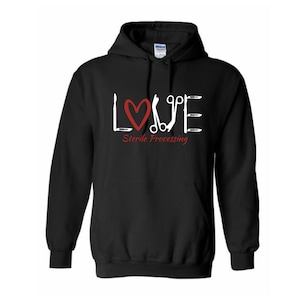 May include: Black hooded sweatshirt with a white graphic of the word "LOVE" made up of medical instruments. The heart in the graphic is red. The text "Sterile Processing" is below the graphic.