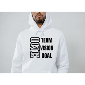 May include: White hooded sweatshirt with the words "ONE TEAM VISION GOAL" in bold black letters. The sweatshirt has a drawstring hood and a front pocket. The text is stacked vertically, with "ONE" on the left and "TEAM VISION GOAL" on the right.