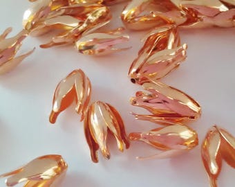 以下が含まれることがあります： ローズゴールドの金属製の花のつぼみのキャップのクローズアップ。キャップは光沢があり、繊細で尖った形をしています。