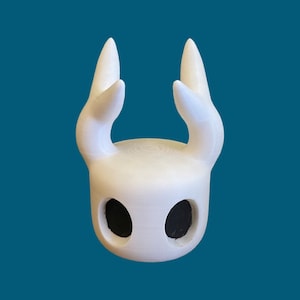 May include: White ceramic figurine of a character with large, pointed ears and two black eye holes. The figurine is a popular video game character.