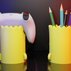 May include: Two yellow pencil holders with a jagged top edge. One holder has a white video game controller inside. The other holder has six colored pencils inside.