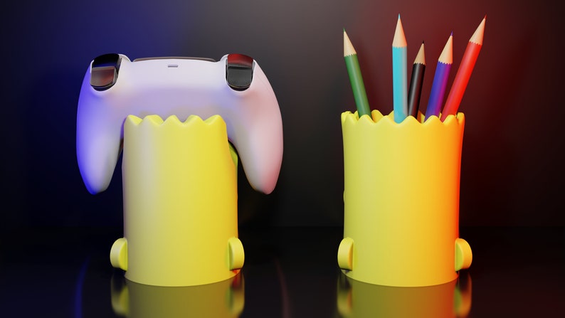 May include: Two yellow pencil holders with a jagged top edge. One holder has a white video game controller inside. The other holder has six colored pencils inside.