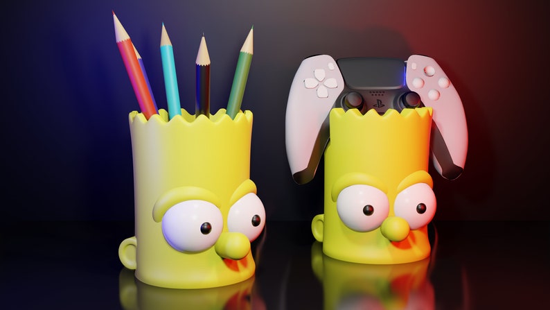 May include: Two yellow Simpsons character pencil holders. One holder has a black and white PlayStation 5 controller on top. The other holder has five colored pencils inside.