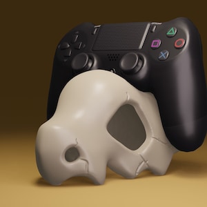 Könnte beinhalten: Ein schwarzer Videospiel-Controller mit einem weißen, schädelförmigen Objekt, das darauf liegt.