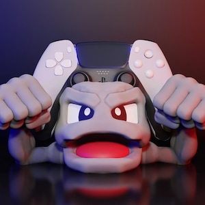 May include: A gray, cartoon-like figure with a wide mouth and large eyes, holding a white and black video game controller in its hands.