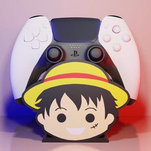 May include: A white and black PlayStation 5 controller with a cartoon character design. The character has a yellow hat with a red band and a scar under the eye. The controller is set against a gradient background.