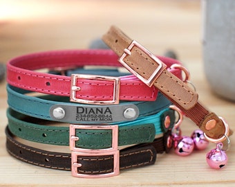 Könnte beinhalten: Vier bunte Katzenhalsbänder mit einer Metallschnalle und einem Namensschild mit der Aufschrift "DIANA 234-852-8844 CALL MY MOM". Die Halsbänder sind übereinander gestapelt und haben einen rosa Glöckchenanhänger am unteren Ende.