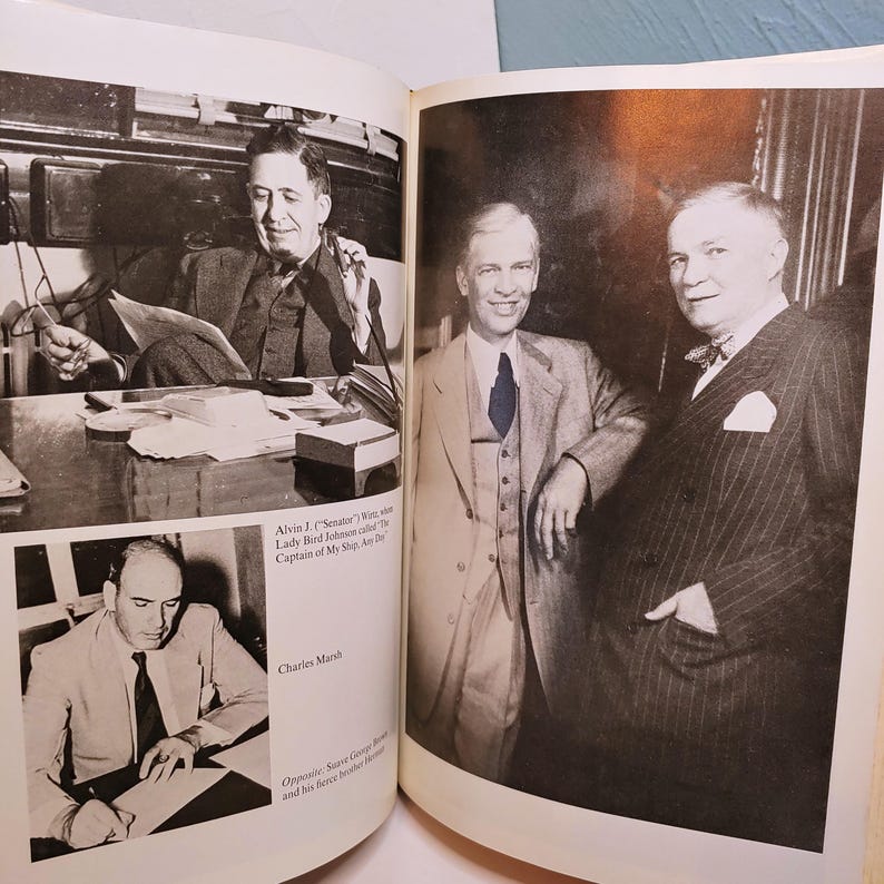 May include: Black and white photograph of three men in suits, one seated at a desk. The image is from a book, with text visible, including "Alvin J. (Senator)" and "Charles Marsh."