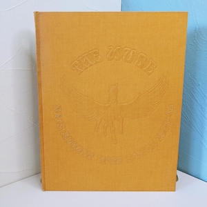 May include: Mustard-colored hardcover book with embossed text and a winged horse design. The text reads "THE MUSE" above the image and "ARTS & AMHERST HIGH SCHOOL 1971-72" below. The book is in good condition.