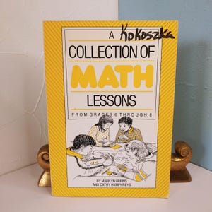 May include: A yellow book titled "A Collection of Math Lessons from Grades 6 Through 8" by Marilyn Burns and Cathy Humphreys. The cover features a black and white illustration of four children working on math problems.