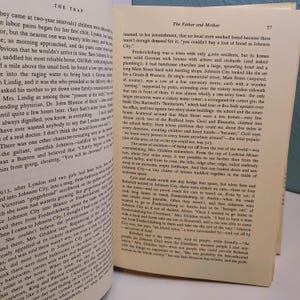 May include: Open book pages with text, featuring the title "The Trap" and "The Father and Mother." The text is in black font on aged, yellowed paper. The pages are slightly curled, suggesting age and use. The book is open to a double-page spread.