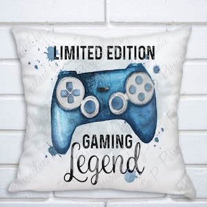 May include: White pillow with a blue watercolor illustration of a video game controller and the text "LIMITED EDITION GAMING Legend".