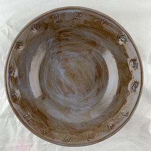Large bowl, stamped chickens and roosters around the edge. Lavender and rust glossy glaze.