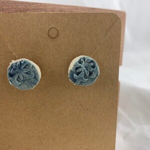 Earrings, round cut out, Art Deco imprint.  Blue.  Hypo-allergenic stud backs. 1/2” across.