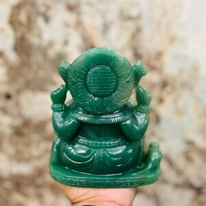 Pu&ograve; includere: Una statua di Ganesha in giada verde con dettagli intricati. La statua &egrave; seduta su una base e ha una parte posteriore rotonda e decorativa.