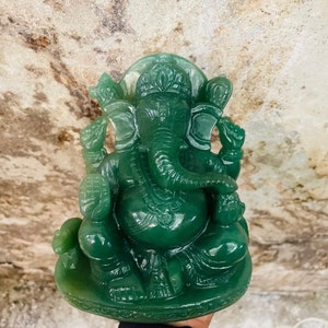 Pu&ograve; includere: Statua di giada verde della divinit&agrave; ind&ugrave; Ganesha. La statua raffigura Ganesha seduto con la proboscide alzata e che tiene un dolce in mano. La statua &egrave; finemente scolpita con dettagli sugli abiti e la testa di elefante.