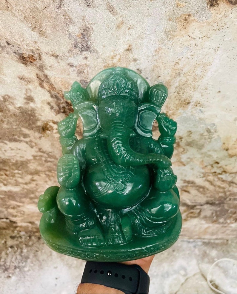 Pu&ograve; includere: Statua di giada verde della divinit&agrave; ind&ugrave; Ganesha. La statua raffigura Ganesha seduto con la proboscide alzata e che tiene un dolce in mano. La statua &egrave; finemente scolpita con dettagli sugli abiti e la testa di elefante.