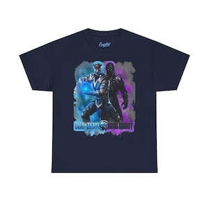 May include: A navy blue short-sleeved t-shirt featuring a graphic print of the characters Sub-Zero and Noob Saibot. Sub-Zero is shown in blue with a glowing orb, while Noob Saibot is in black and purple. The text reads Sub-Zero and Noob Saibot.